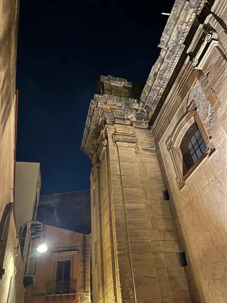 Palazzo storico illuminato di notte nel centro di Sciacca